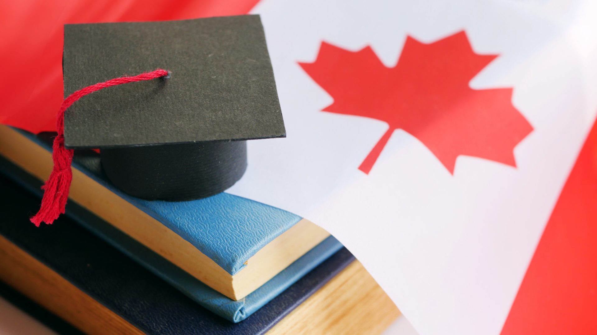 Graduation cap on stack of books. Canada education concept. Class of