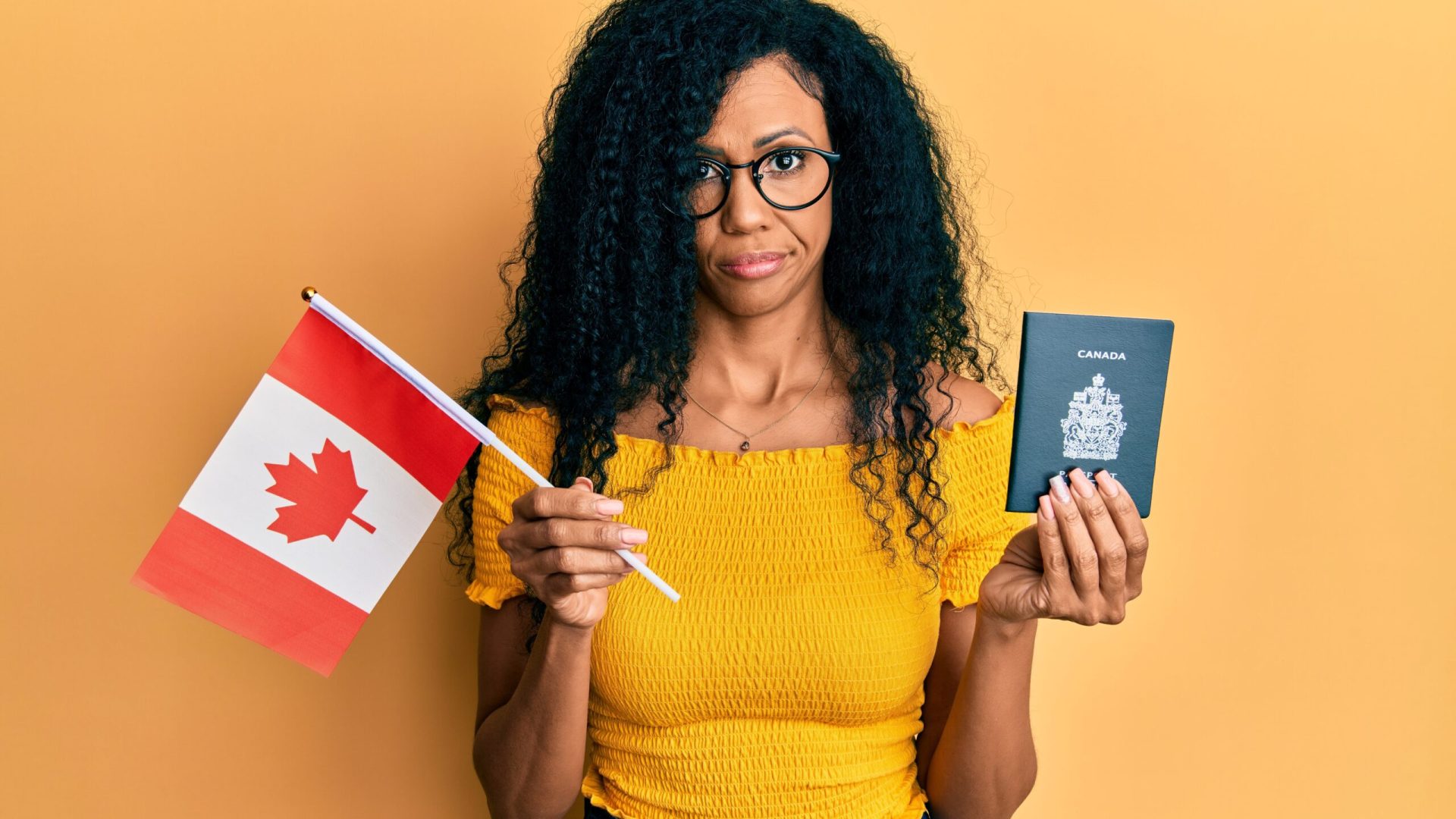 Middle age african american woman holding canada flag and passport skeptic and nervous, frowning upset because of problem. negative person.