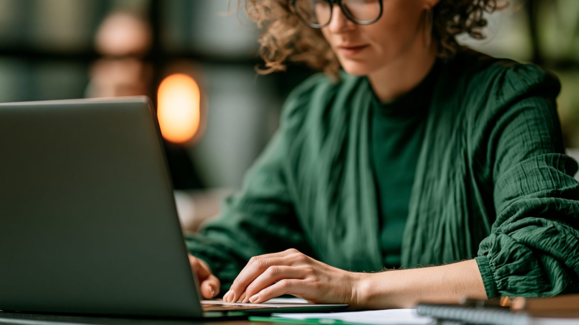 professional woman reviewing documents on laptop in modern office