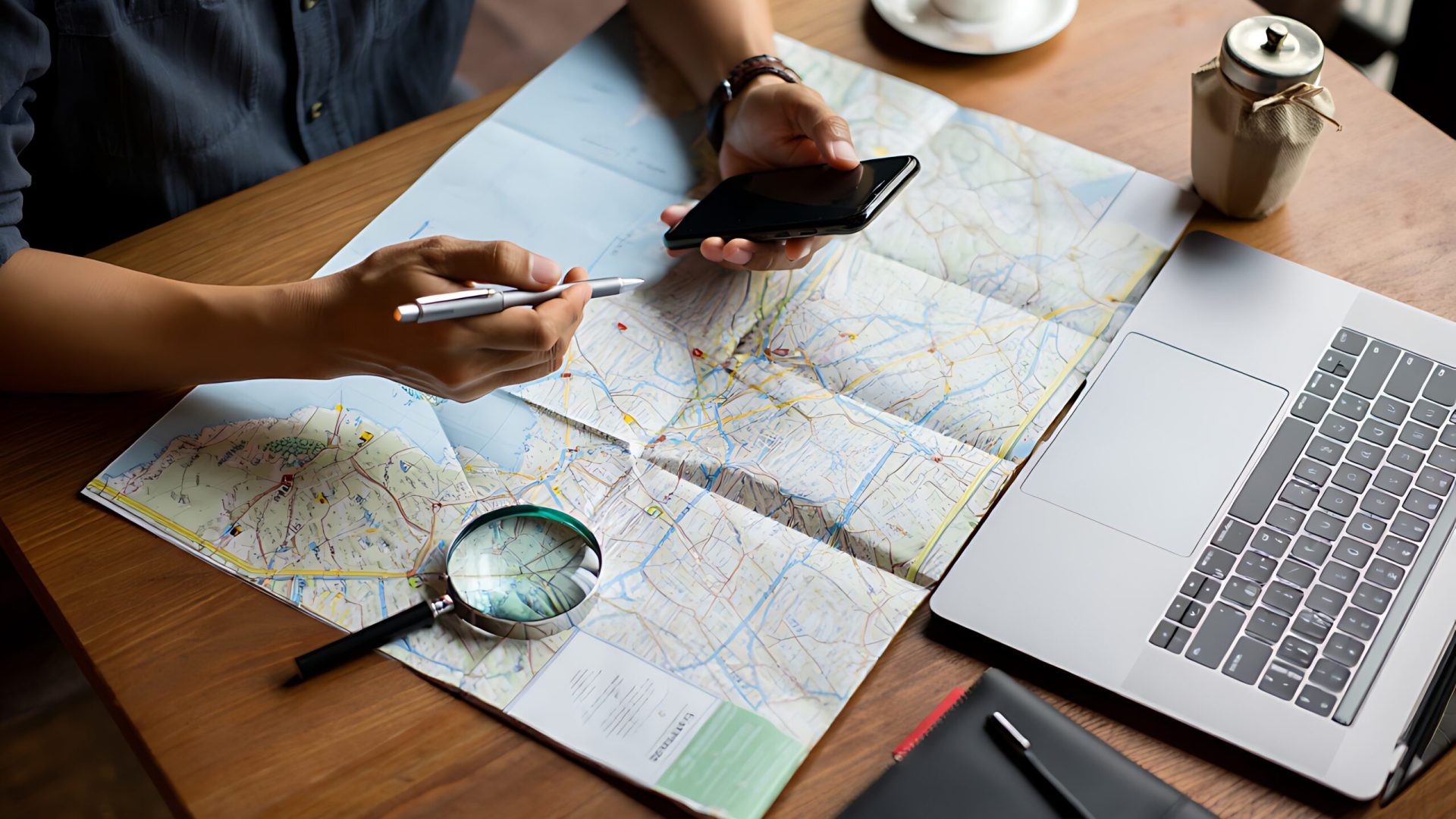 Travel planning with map phone laptop magnifying glass planning smartphone computer vacation destination research