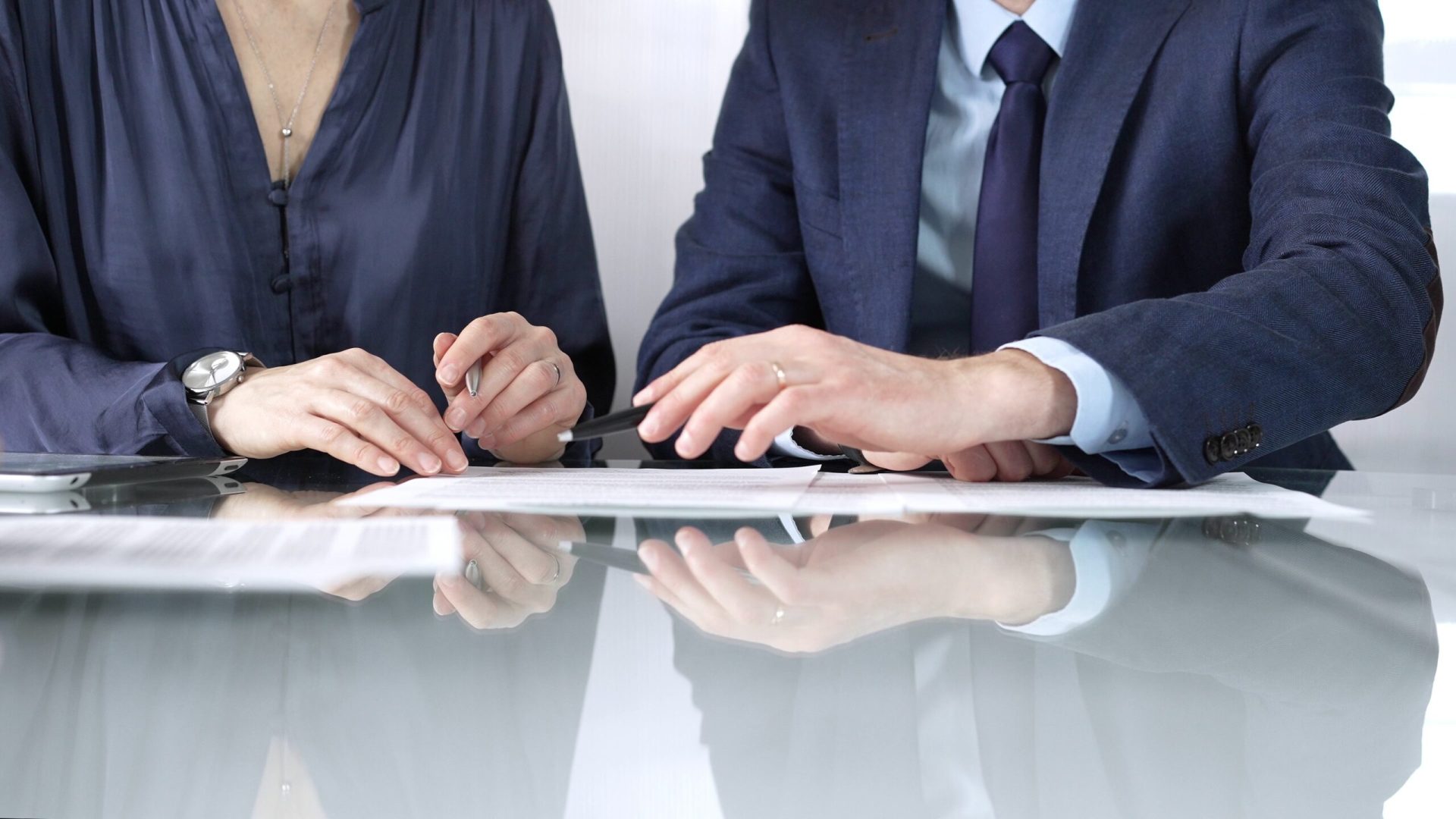 Business partners or lawyers are discussing contract papers during a meeting, negotiating and making decisions together. Business people concept, close up.