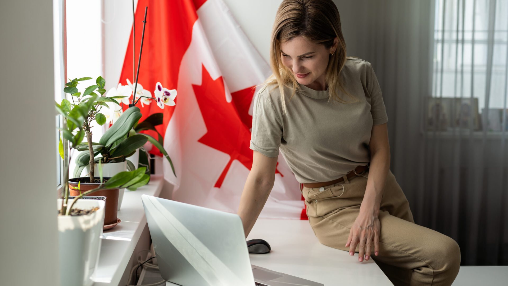 cropped view of female student with canadian flag presenting laptop . High quality photo