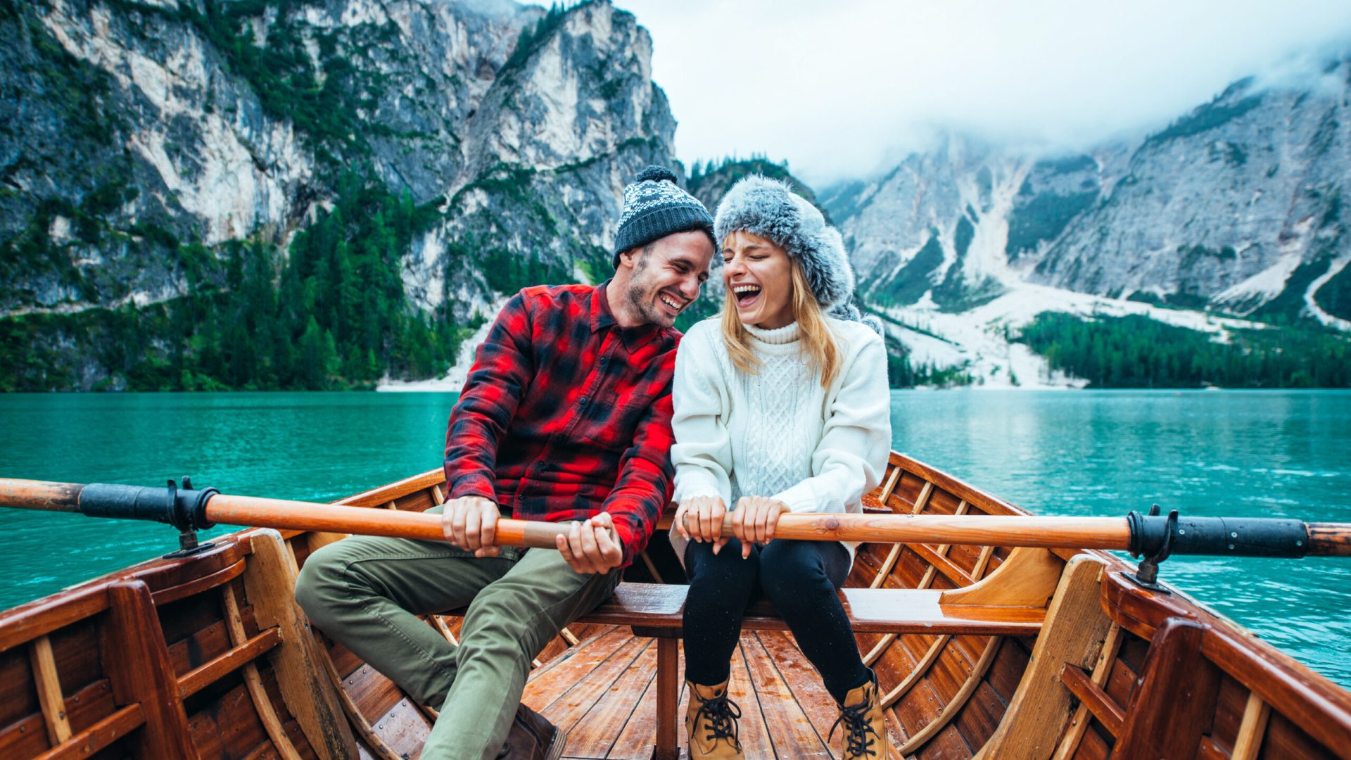 Mountain stories. Happy couple on a wanderlust vacation. Boyfriend and girlfriend spending time together at the lake. Storytelling concept about lifestyle and winter travels
