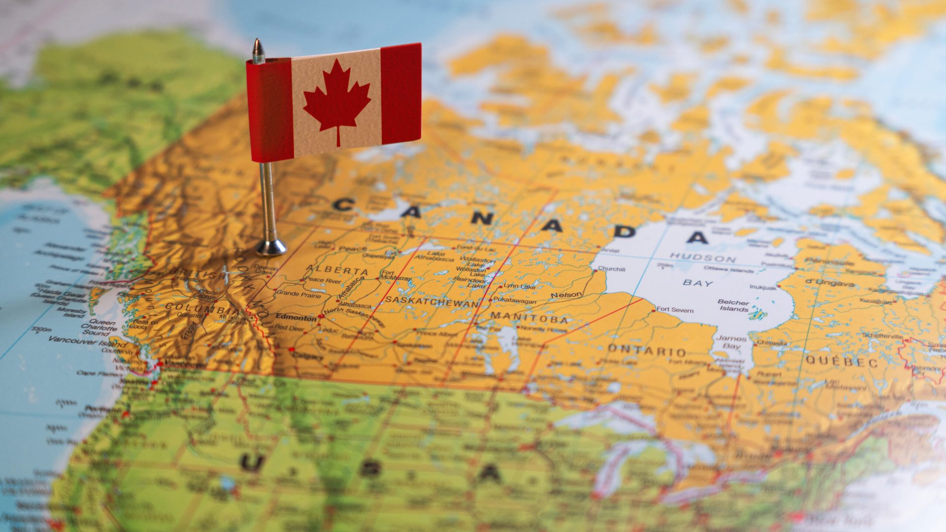 A Canadian flag pinpointed on a map of Canada, symbolizing national identity and geographical location. High quality photo