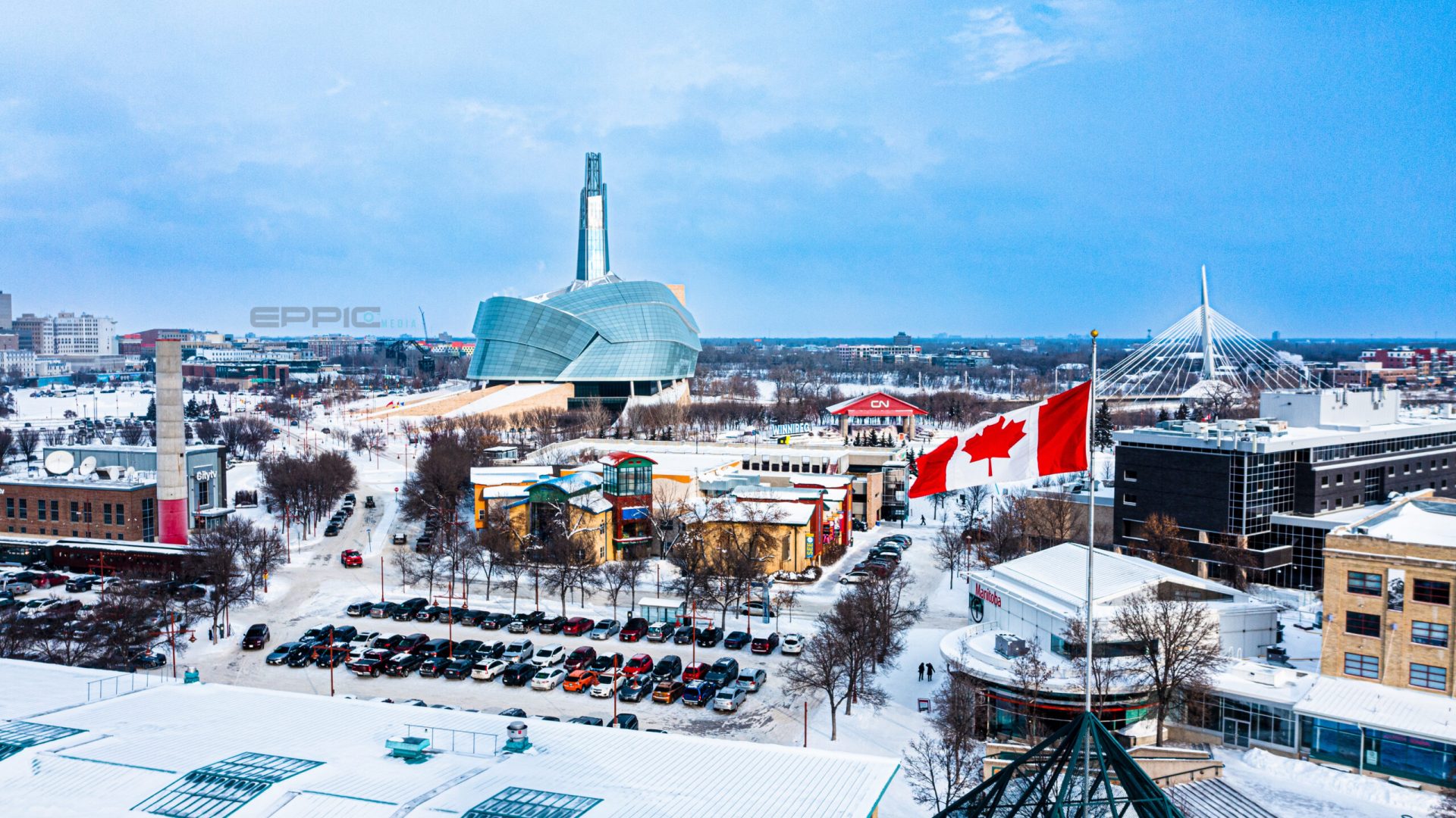 Canadian flag blowing in the wind with Human rights museum in the background.  Winnipeg, Manitoba.  Winter.
