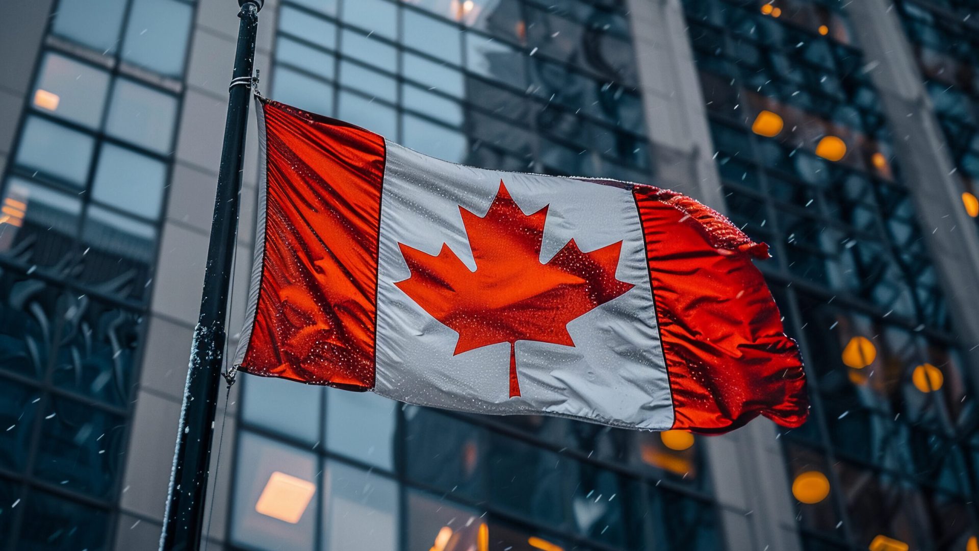 Canadian Flag Waving in Front of City Building on a Snowy Day