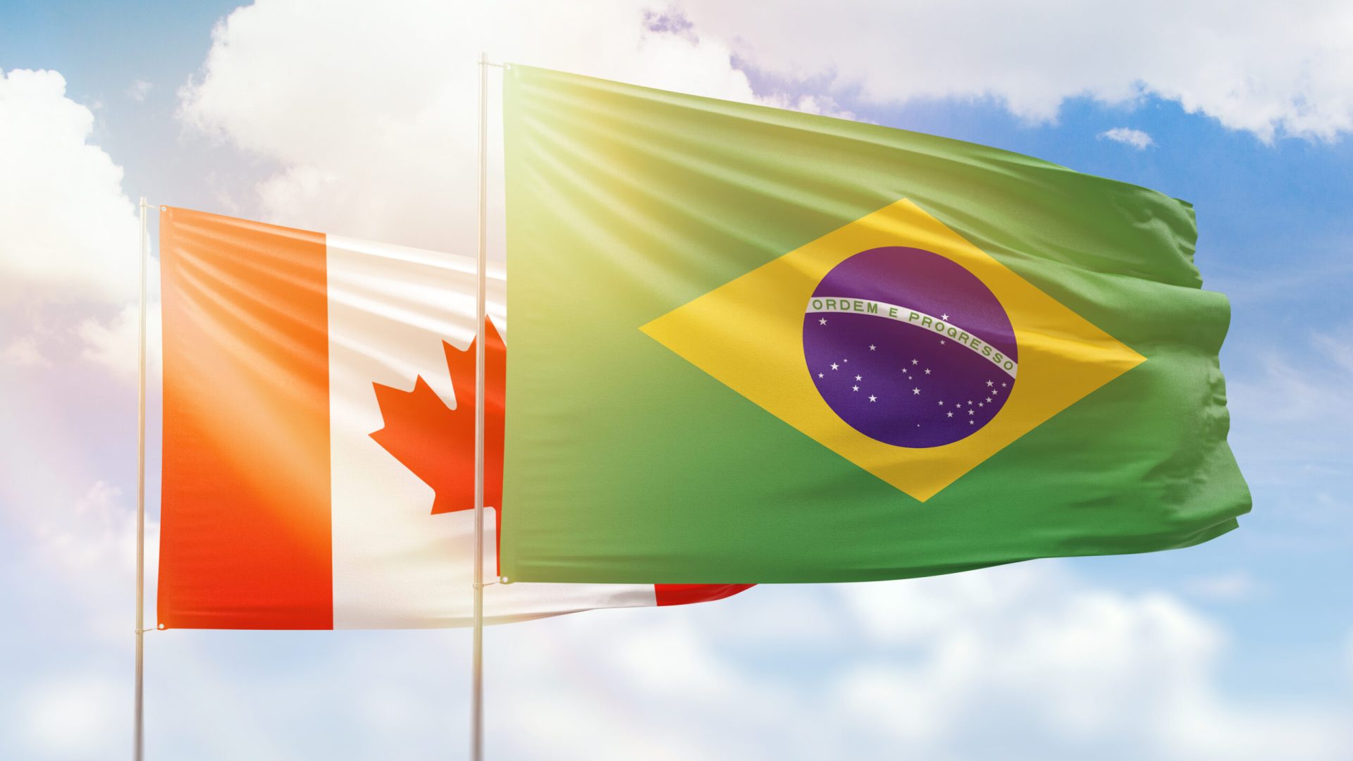 Sunny blue sky and flags of brazil and canada